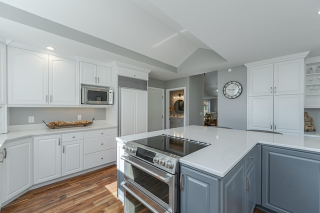 kitchen featuring white cabinetry, light countertops, dark wood-style flooring, and built in appliances