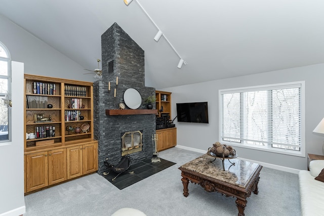 living room with light colored carpet, a fireplace, baseboards, vaulted ceiling, and rail lighting