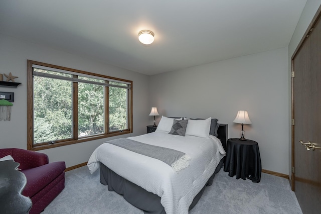 bedroom featuring baseboards and light colored carpet