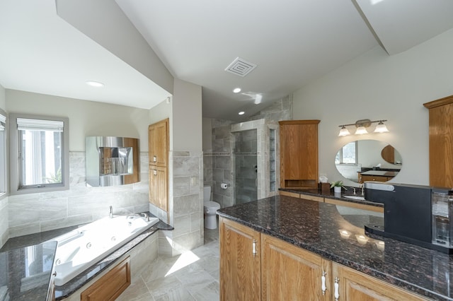 full bathroom featuring toilet, vanity, visible vents, vaulted ceiling, and a whirlpool tub