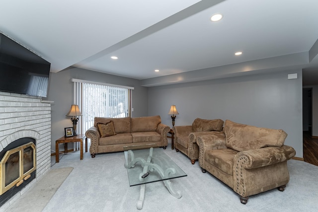 living room with recessed lighting, light colored carpet, and a fireplace