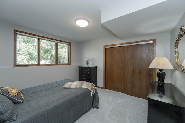 bedroom with light carpet and a closet