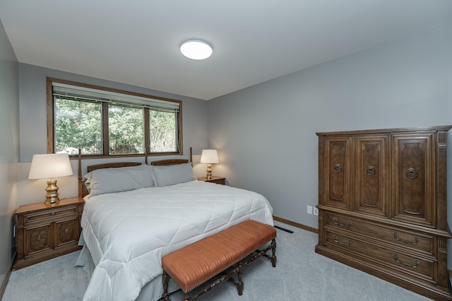 bedroom with light carpet and baseboards