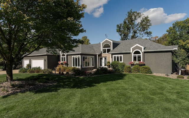 view of front of property with a garage, a front yard, and stucco siding