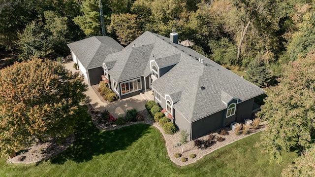 birds eye view of property featuring a forest view