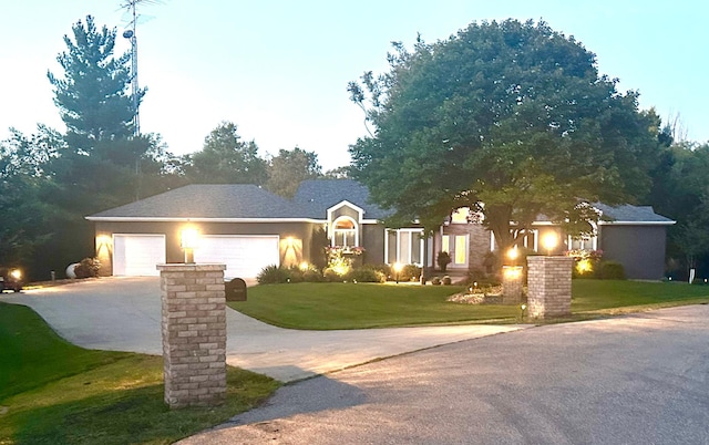 view of front of property with a garage, driveway, and a lawn