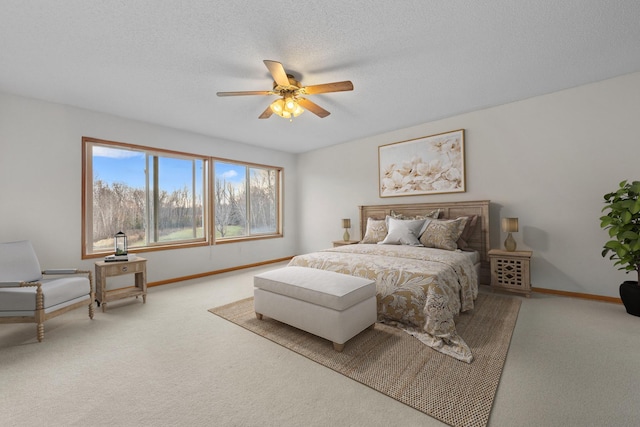 carpeted bedroom featuring ceiling fan and a textured ceiling