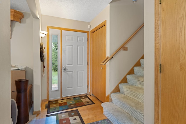 foyer entrance featuring light hardwood / wood-style flooring and a textured ceiling