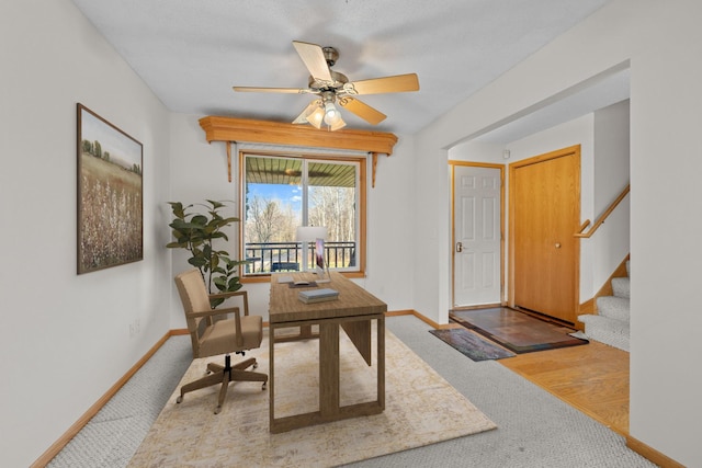 carpeted home office featuring ceiling fan