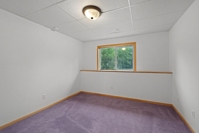 carpeted spare room featuring a paneled ceiling