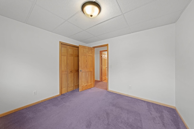 carpeted spare room with a drop ceiling