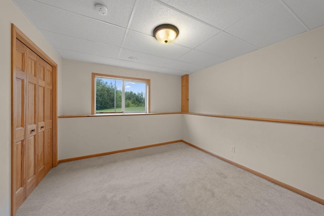 carpeted empty room featuring a paneled ceiling