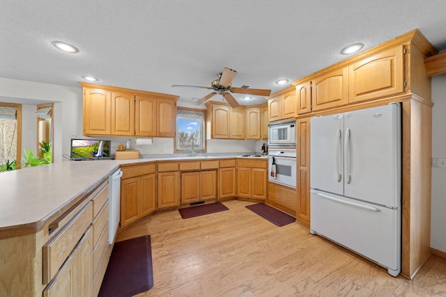 kitchen with ceiling fan, sink, a textured ceiling, white appliances, and light wood-type flooring