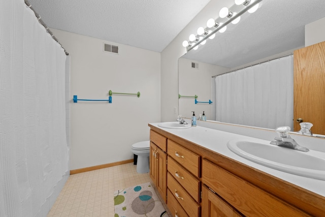 bathroom featuring vanity, a shower with shower curtain, a textured ceiling, and toilet