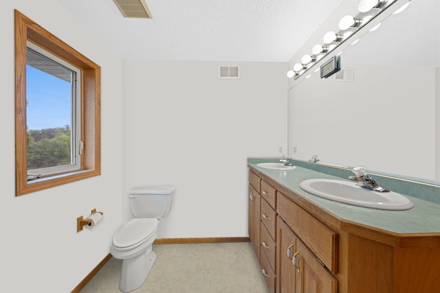 bathroom with vanity, a textured ceiling, and toilet