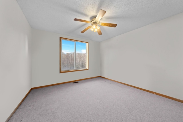 carpeted empty room with a textured ceiling and ceiling fan