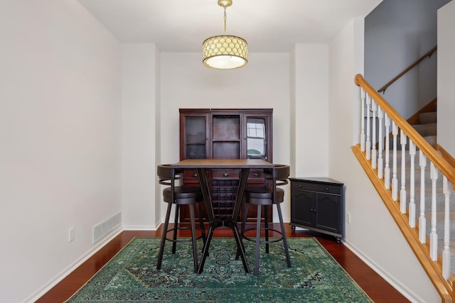 dining area featuring bar area and dark hardwood / wood-style floors