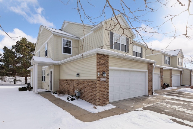 exterior space with an attached garage, driveway, and brick siding