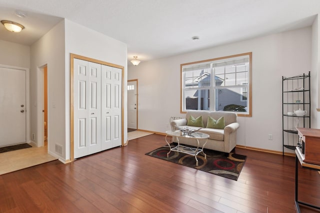 entryway with wood finished floors, visible vents, and baseboards