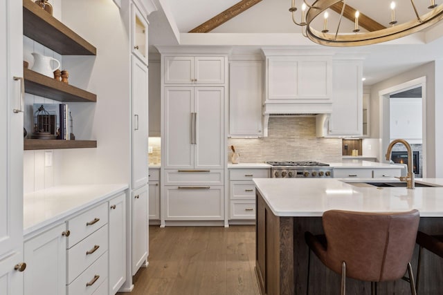 kitchen featuring sink, backsplash, white cabinets, and beam ceiling