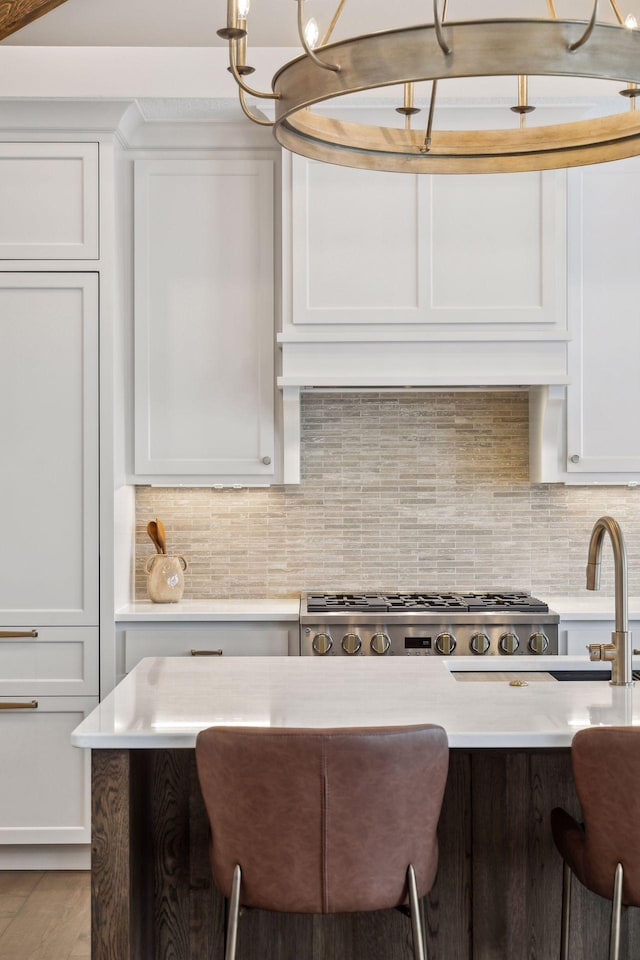 kitchen featuring a breakfast bar, white cabinets, and tasteful backsplash