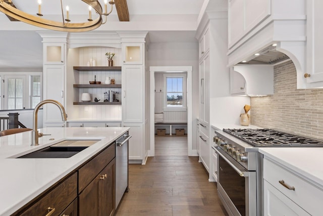 kitchen featuring backsplash, sink, hanging light fixtures, dark wood-type flooring, and stainless steel appliances