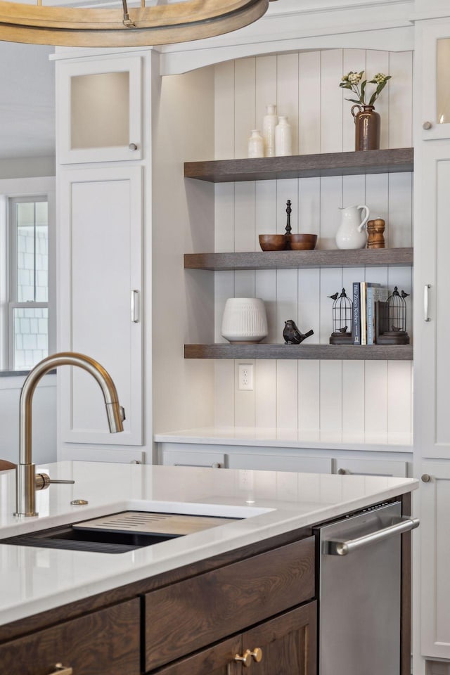 kitchen with dark brown cabinets, stainless steel dishwasher, white cabinets, and sink