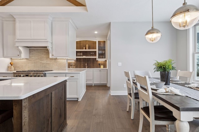 kitchen with tasteful backsplash, dark hardwood / wood-style floors, pendant lighting, stove, and white cabinetry