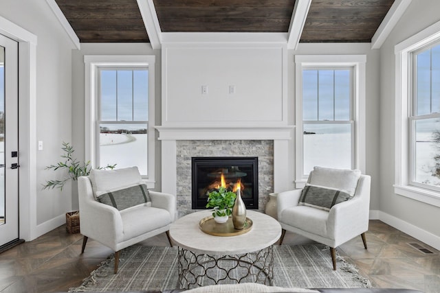 sitting room with a fireplace, dark parquet flooring, wood ceiling, and vaulted ceiling with beams