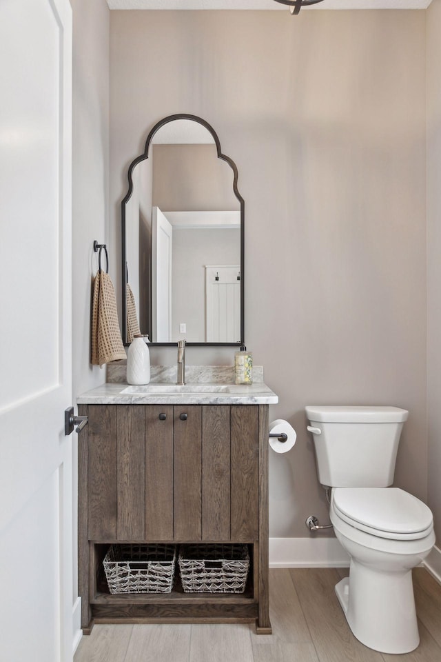 bathroom featuring hardwood / wood-style flooring, toilet, and vanity