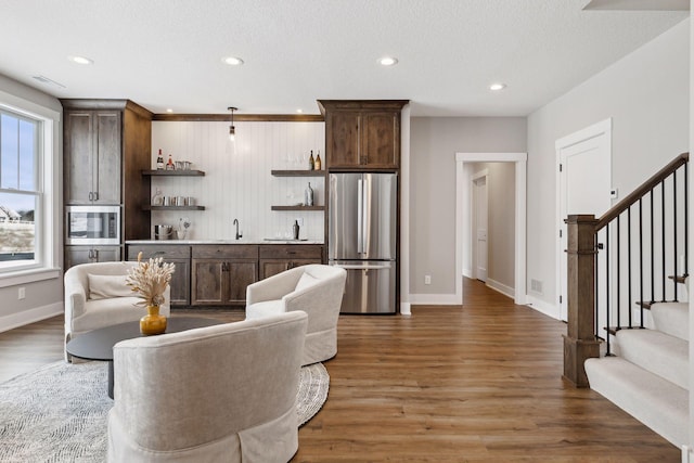 living room featuring dark wood-type flooring, a textured ceiling, and sink