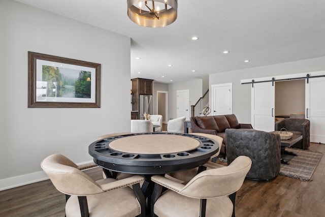 dining room with dark wood-type flooring and a barn door