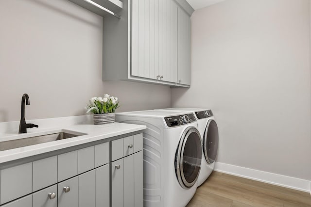 14320 47th St N, Stillwater, MN 55082 - laundry room featuring cabinet space, washer and clothes dryer, and light wood-style flooring