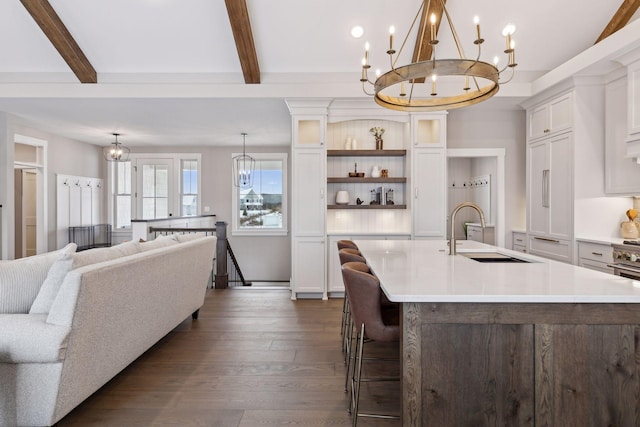 14320 47th St N, Stillwater, MN 55082 - kitchen featuring a chandelier, light countertops, a kitchen island with sink, dark wood finished floors, and beam ceiling