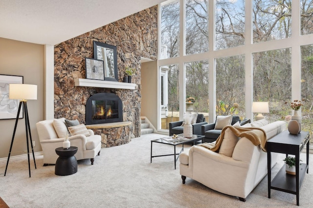 living room with carpet flooring, a stone fireplace, and a textured ceiling