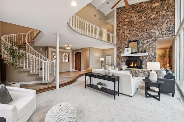 carpeted living room featuring a fireplace and a high ceiling