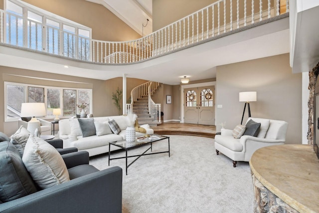 living room with plenty of natural light, wood-type flooring, and high vaulted ceiling