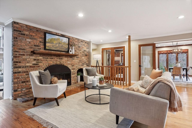 living room with a fireplace, light wood-type flooring, and crown molding