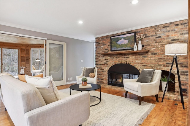 living room with a fireplace, light hardwood / wood-style floors, and ornamental molding