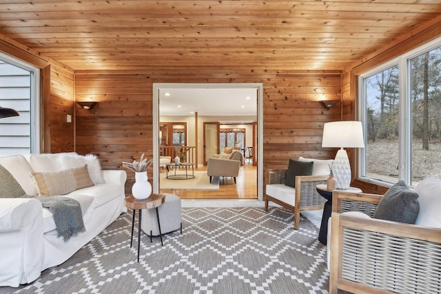 living room featuring light hardwood / wood-style floors, wooden ceiling, and wooden walls