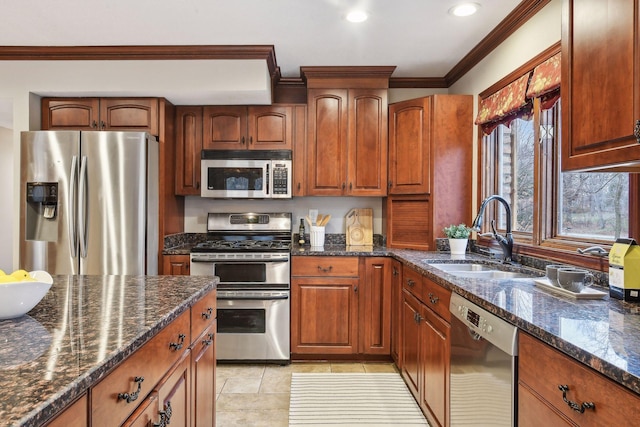 kitchen featuring ornamental molding, sink, appliances with stainless steel finishes, and dark stone counters