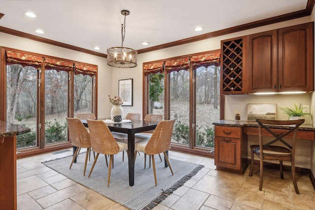 dining room with a healthy amount of sunlight, crown molding, and a chandelier