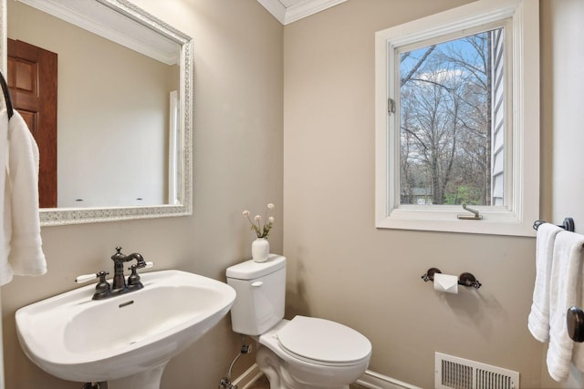 bathroom featuring crown molding, plenty of natural light, sink, and toilet