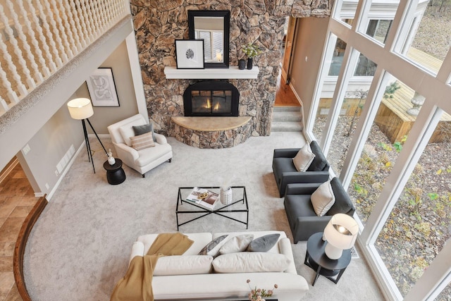 living room featuring carpet flooring and a stone fireplace