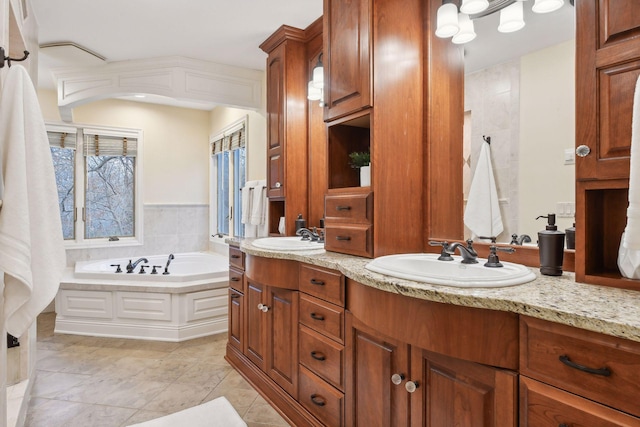 bathroom featuring tile patterned flooring, vanity, and a tub to relax in