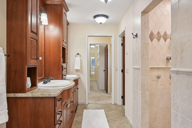 bathroom featuring a tile shower, tile patterned floors, and vanity