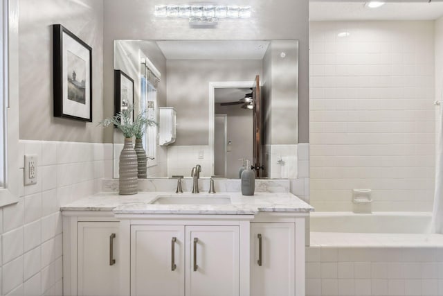 bathroom featuring tiled shower / bath, vanity, and ceiling fan