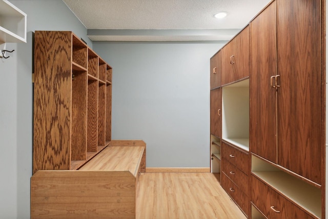 mudroom featuring light wood-type flooring and a textured ceiling