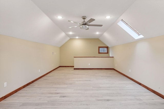 bonus room with lofted ceiling with skylight and light hardwood / wood-style floors