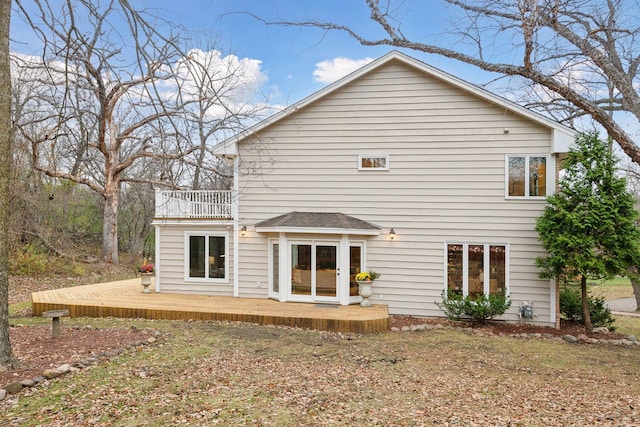 rear view of property featuring a balcony and a deck